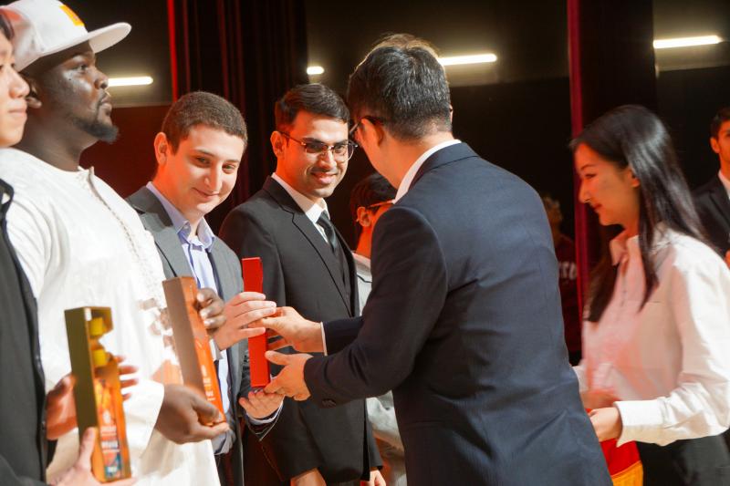 A group of people standing around each other
Description automatically generated