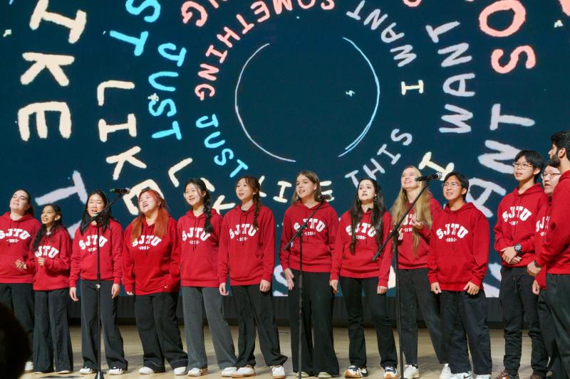 A group of young women singing on stage
Description automatically generated