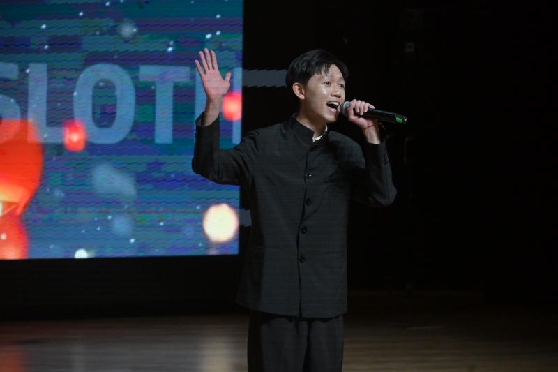 A person holding a microphone
Description automatically generated