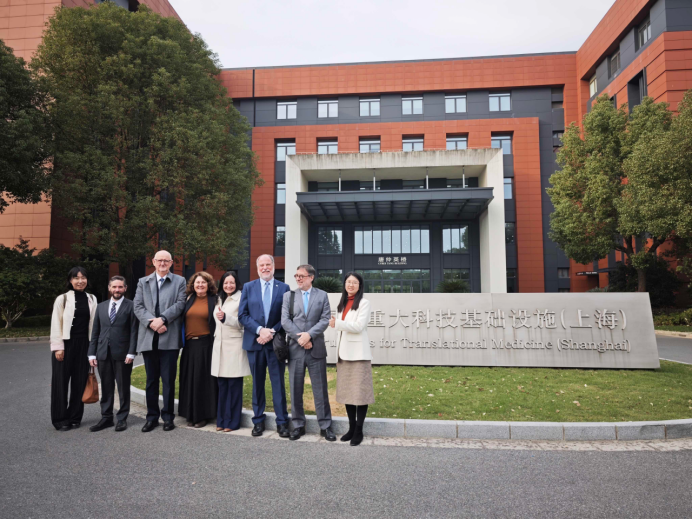 A group of people standing in front of a building

Description automatically generated