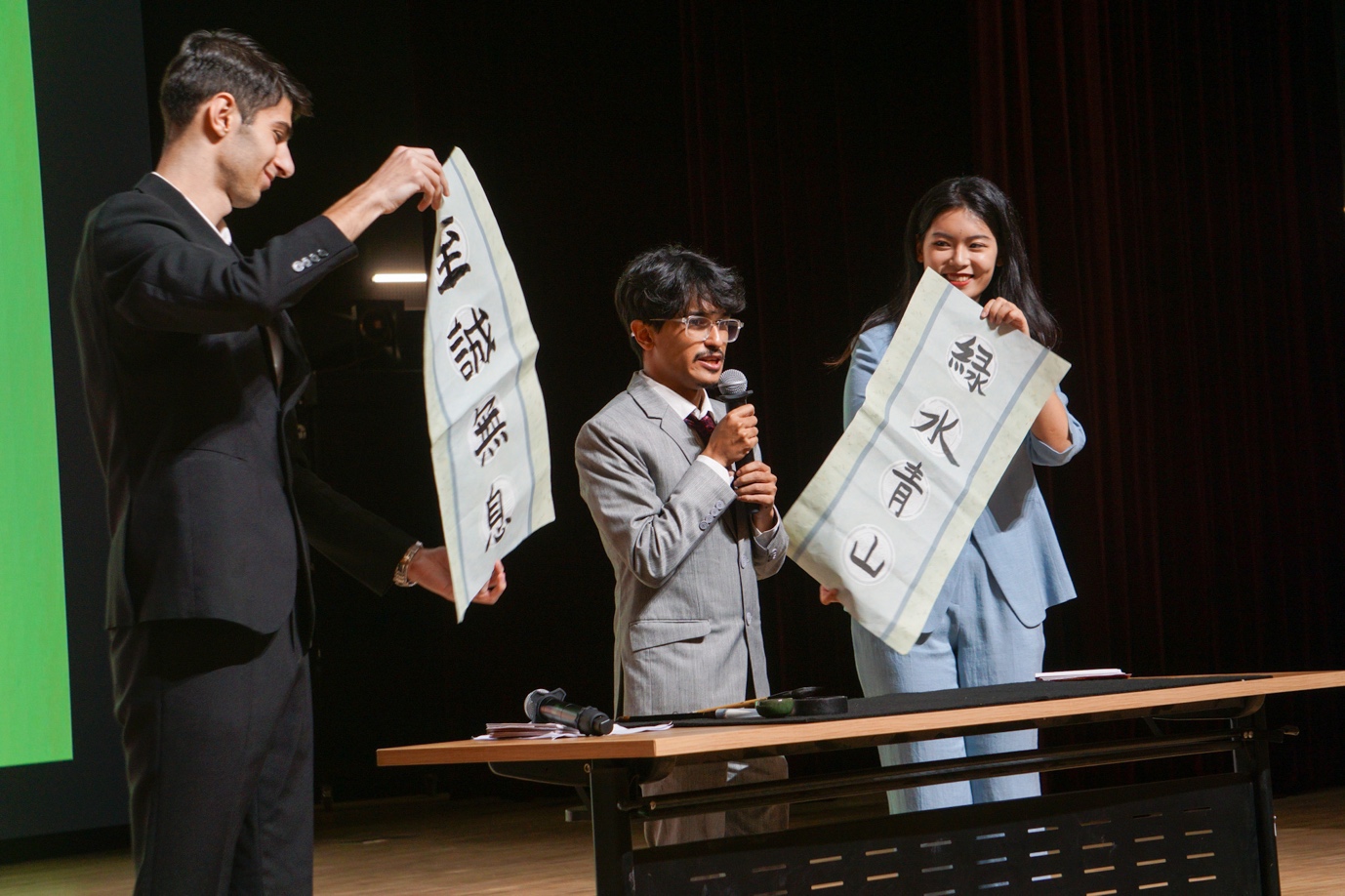 A group of people holding a sign
Description automatically generated